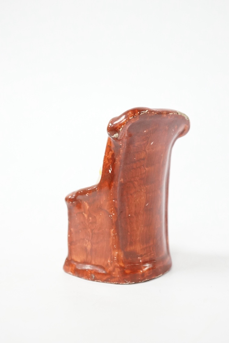 A rare Staffordshire pearlware group of a girl seated in a chair holding a smiling cat, c.1800-10. Condition - restoration to the front of the base by her feet